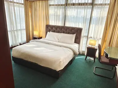a bedroom with a large bed in a room with windows at KL Cozy Suite Apartment At Times Square in Kuala Lumpur
