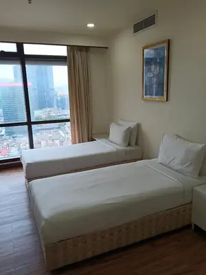 two beds in a hotel room with a large window at KL Cozy Suite Apartment At Times Square in Kuala Lumpur