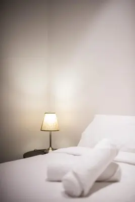 a white bed with a lamp on a table at Bangsar Signature By PSM in Kuala Lumpur