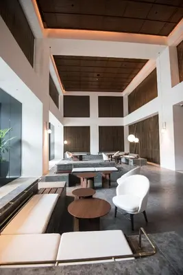 a lobby with tables and chairs in a building at Bangsar Signature By PSM in Kuala Lumpur