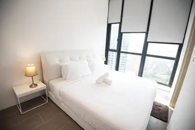 a bedroom with a white bed with a teddy bear on it at Bangsar Signature By PSM in Kuala Lumpur