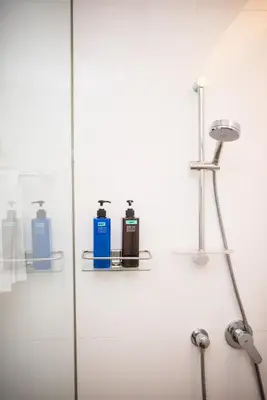 a shower with three bottles on a glass wall at Bangsar Signature By PSM in Kuala Lumpur