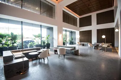 a lobby with tables and chairs and large windows at Bangsar Signature By PSM in Kuala Lumpur