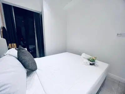 a white bed with a vase of flowers on it at Axon Residence Bukit Bintang Pavilion KL in Kuala Lumpur