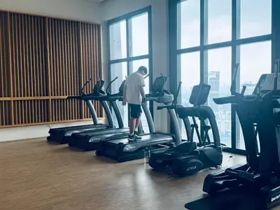 a man standing on a treadmill in a gym at Axon Residence Bukit Bintang Pavilion KL in Kuala Lumpur