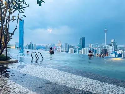 a group of people in a infinity pool with a city skyline at Axon Residence Bukit Bintang Pavilion KL in Kuala Lumpur