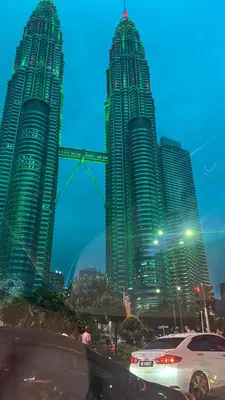 two tall skyscrapers in a city at night at Vortex Suites klcc By Sky House in Kuala Lumpur
