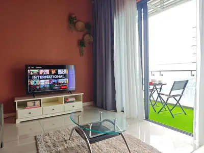 a living room with a tv and a glass table at The Element Condo 3BR with KL Skyscraper View in Kuala Lumpur