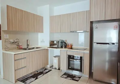 a kitchen with wooden cabinets and a stainless steel refrigerator at The Element Condo 3BR with KL Skyscraper View in Kuala Lumpur
