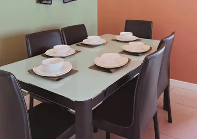a dining room table with chairs and plates on it at The Element Condo 3BR with KL Skyscraper View in Kuala Lumpur