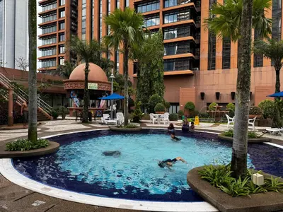 a pool with people swimming in it in front of a building at Times Square Service Suites KL, Fortune in Kuala Lumpur