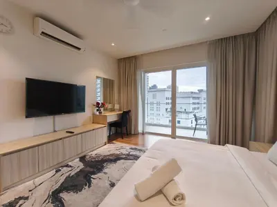 a hotel room with a flat screen tv and a bed at Quill Residences KLCC, Fortune in Kuala Lumpur