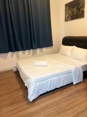 a white bed with a black headboard in a room at The E48-10 Stay in Kuala Lumpur