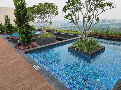 a swimming pool with trees and blue water at SerenityStayatRiveria KL Sentral in Kuala Lumpur