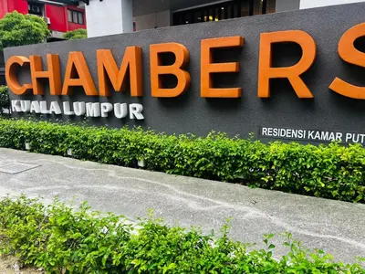 a sign for a chiger building in front of some bushes at Chambers Kl by MRJ in Kuala Lumpur