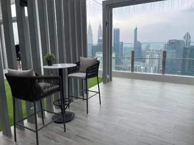a balcony with a table and chairs and a view of the city at Agile SkyView Suites KL in Kuala Lumpur