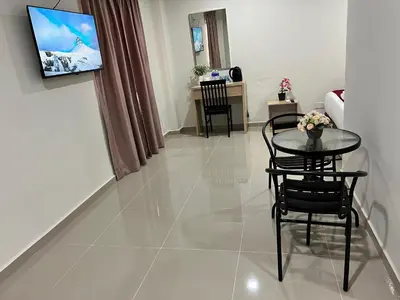a living room with a table and chairs in a room at De Royal Hotel in Ampang