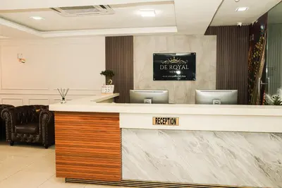 a lobby with a reception desk with a sign that reads be novel at De Royal Hotel in Ampang