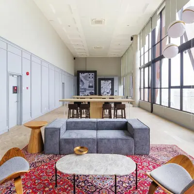 a living room with a couch and tables and windows at Scarletz Suites KLCC by WSD in Kuala Lumpur