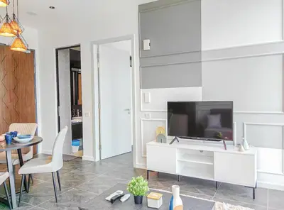 a living room with a television and a table and chairs at Scarletz Suites KLCC by WSD in Kuala Lumpur