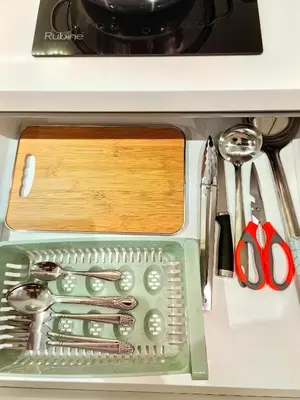 a green container filled with utensils on a counter at Chamber Residence By SKY Rainbow in Kuala Lumpur