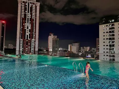 a little girl standing on top of a swimming pool at Chamber Residence By SKY Rainbow in Kuala Lumpur