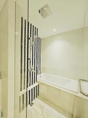 a bathroom with a tub and a glass shower at PANORAMIC SUITES at Eaton residence in Kuala Lumpur
