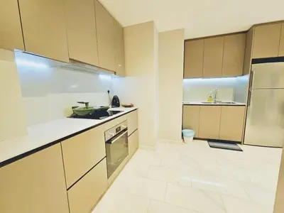 a kitchen with white cabinets and a white tile floor at PANORAMIC SUITES at Eaton residence in Kuala Lumpur
