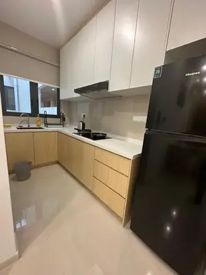 a kitchen with white cabinets and a black refrigerator at Muji Feel Sunway Velocity 2 Link to Mall 2Br in Kuala Lumpur