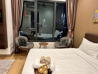 a hotel room with a bed and a window with chairs at LUCENTIA RESIDENCE BY Glory Home in Kuala Lumpur