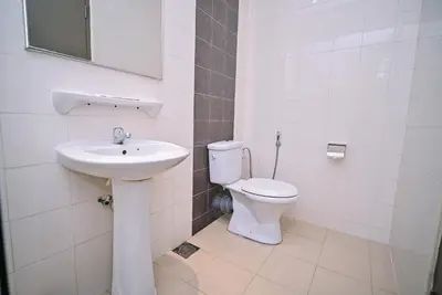 a white bathroom with a toilet and a sink at Kingston Hotel 11 - PWTC, KL in Kuala Lumpur