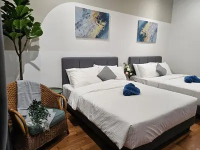 two beds and a chair in a room at Nyiur Premier Residence Ampang Near KLCC Kuala Lumpur in Kuala Lumpur