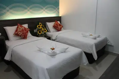 three beds in a room with flowers on them at Signature Hotel @ Bangsar South in Kuala Lumpur