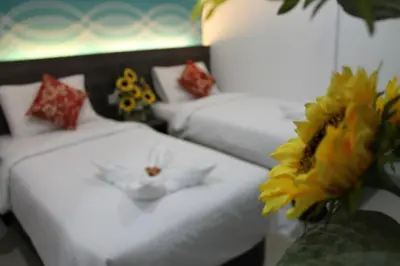 two beds in a room with flowers on them at Signature Hotel @ Bangsar South in Kuala Lumpur