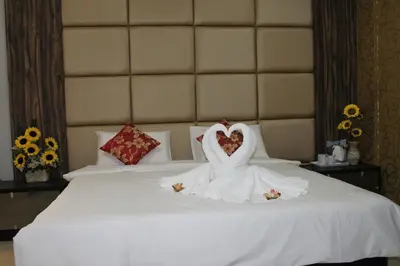 a bride and groom dressed in white sitting on a bed at Signature Hotel @ Bangsar South in Kuala Lumpur
