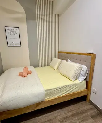a small bedroom with a bed with yellow sheets at Central of KL 1-5px - 10 mins TRX and Bukit Bintang in Kuala Lumpur