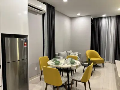 a kitchen and dining room with a table and yellow chairs at Societe by Bamboo Hospitality in Kuala Lumpur