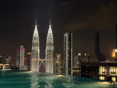 a view of the petronas twin towers at night at Eaton Residence KLCC in Kuala Lumpur