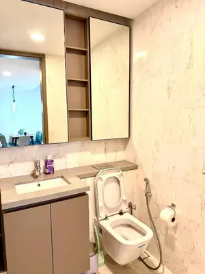a bathroom with a toilet and a sink and a mirror at Eaton Residence KLCC in Kuala Lumpur
