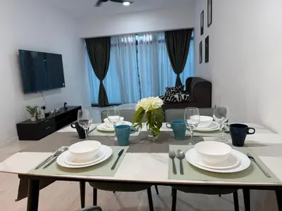 a dining room table with plates and wine glasses at Eaton Residence KLCC in Kuala Lumpur