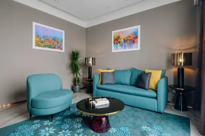 a living room with a blue couch and two chairs at Imperial KLCC by Premium Hospitality in Kuala Lumpur