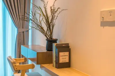 a shelf with a book and a vase with a plant at Eaton Kuala Lumpur with KLCC Skyline View Pool in Kuala Lumpur