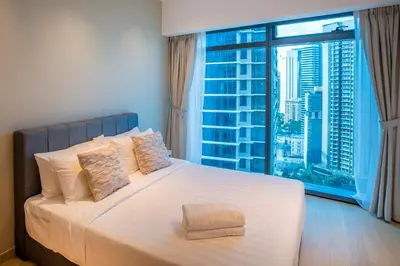 a bedroom with a white bed with a large window at Eaton Kuala Lumpur with KLCC Skyline View Pool in Kuala Lumpur
