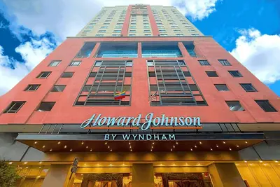 a tall red building with a sign on it at Howard Johnson By Wyndham Kuala Lumpur 118 in Kuala Lumpur