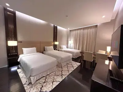 a hotel room with two beds and a desk at Bukit Bintang Cityscape in Kuala Lumpur