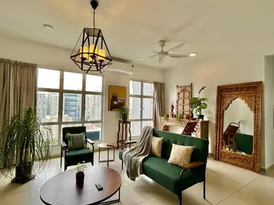 a living room with a green couch and a table at 3BR Vintage design Level 26, KL Sentral City View in Kuala Lumpur