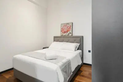 a bedroom with a large bed with white sheets at KL Panorama in Kuala Lumpur