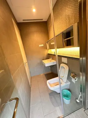 a small bathroom with a toilet and a sink at Lucentia Global Luxe Suites Kuala Lumpur in Kuala Lumpur
