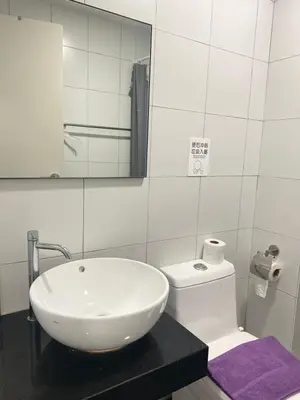 a bathroom with a white sink and a toilet at Serenity Stay in Chambers Residence in Kuala Lumpur