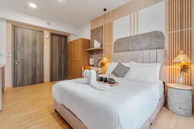 a bedroom with a large bed with a white bedspread at Woody Studio Agile Bukit Bintang by RumaBnB in Kuala Lumpur